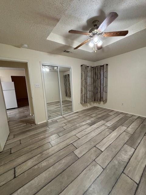 2413 Markland St, Irving, TX 75060 - unfurnished room featuring a textured ceiling, a ceiling fan, wood finished floors, and baseboards