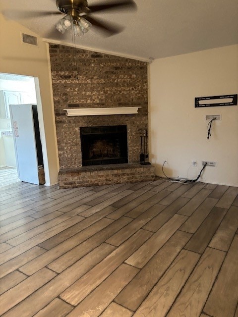 unfurnished living room featuring ceiling fan, hardwood / wood-style flooring, and a fireplace