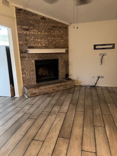 2413 Markland St, Irving, TX 75060 - unfurnished living room featuring a brick fireplace, wood finished floors, and vaulted ceiling