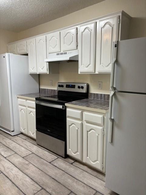 2413 Markland St, Irving, TX 75060 - kitchen featuring freestanding refrigerator, electric stove, under cabinet range hood, light wood-type flooring, and a textured ceiling