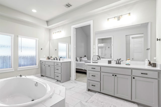 bathroom with vanity and tiled tub