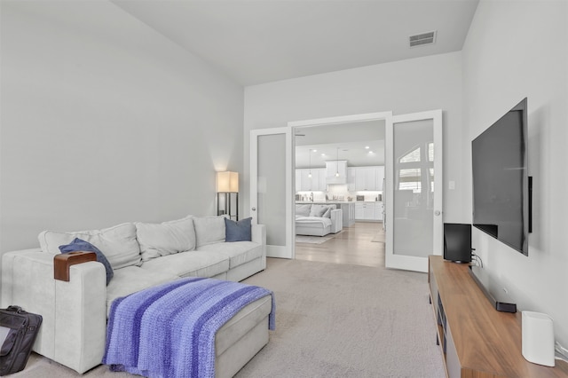 living room with french doors and light carpet