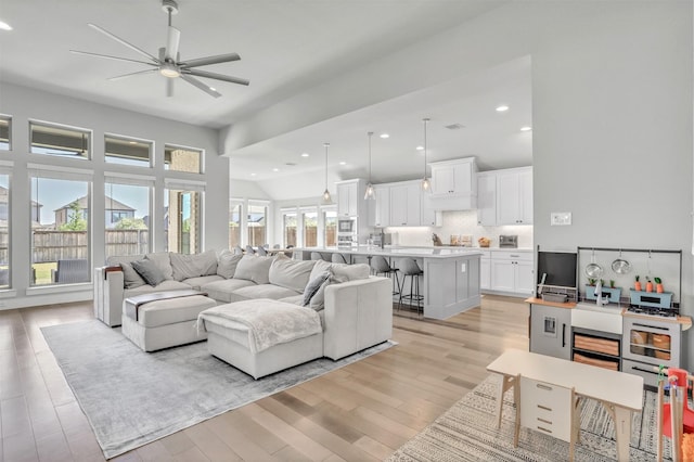 living room with ceiling fan and light hardwood / wood-style flooring