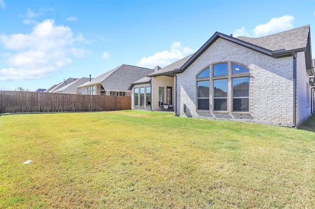 rear view of property with a yard