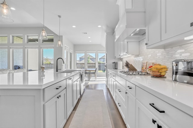 kitchen with sink, white cabinetry, stainless steel gas cooktop, and a spacious island