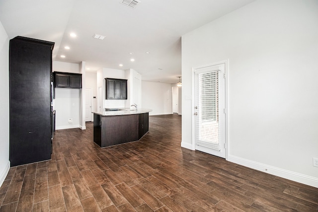 kitchen featuring dark hardwood / wood-style flooring and a center island with sink