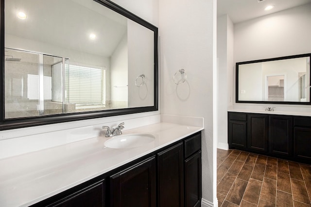 bathroom with vanity, wood-type flooring, walk in shower, and vaulted ceiling