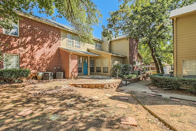 rear view of property featuring a patio area, brick siding, and central air condition unit