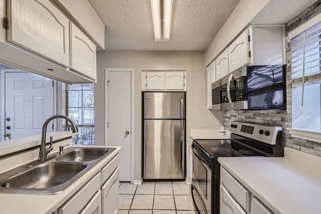 kitchen featuring stainless steel appliances, sink, a wealth of natural light, and white cabinets