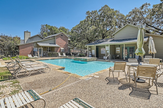 view of pool with french doors and a patio area