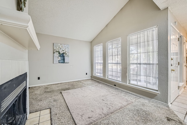 carpeted living room featuring lofted ceiling, a textured ceiling, and a tile fireplace