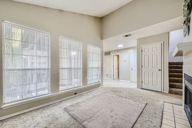 carpeted foyer with a textured ceiling