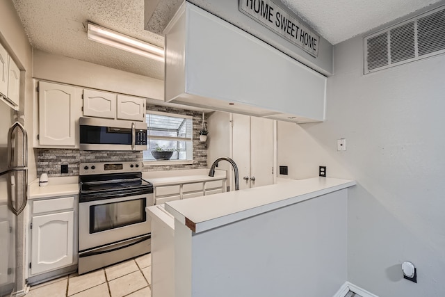 kitchen featuring white cabinets, tasteful backsplash, light tile patterned floors, appliances with stainless steel finishes, and sink