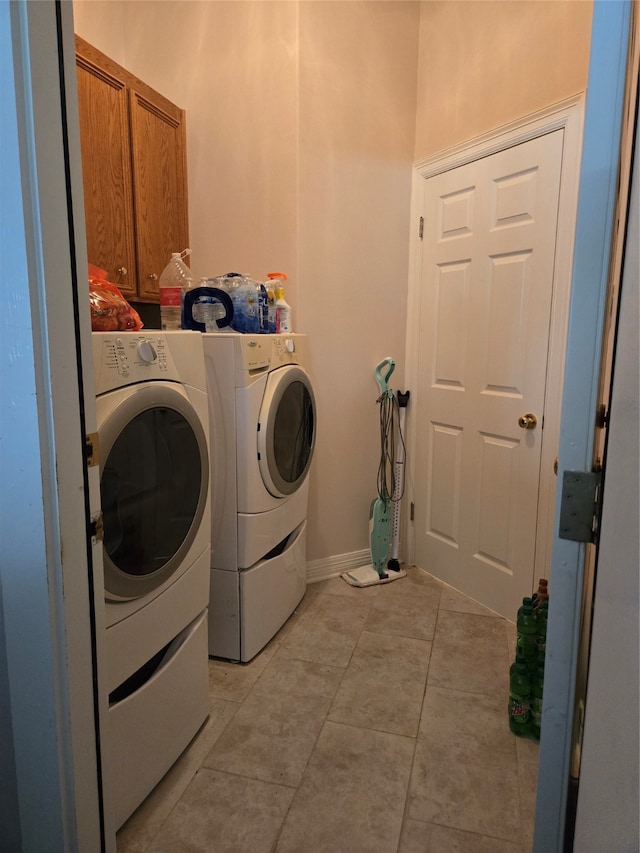 washroom with cabinets, separate washer and dryer, and light tile patterned floors