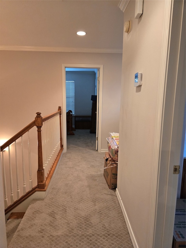 hall with ornamental molding and light carpet