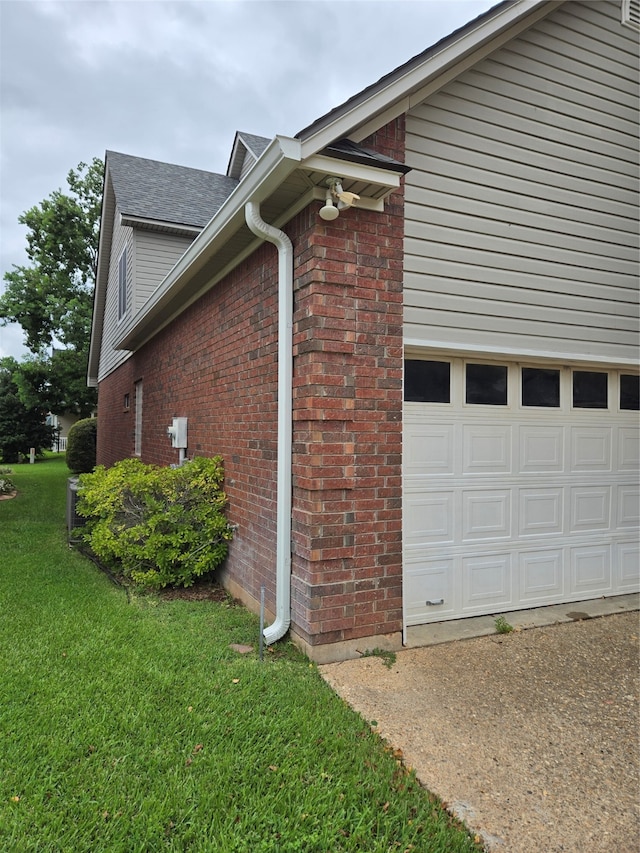 view of side of home with a garage and a lawn