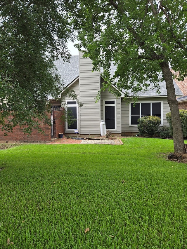 rear view of property featuring a yard