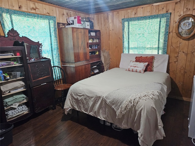 bedroom featuring multiple windows, wood walls, and dark hardwood / wood-style flooring