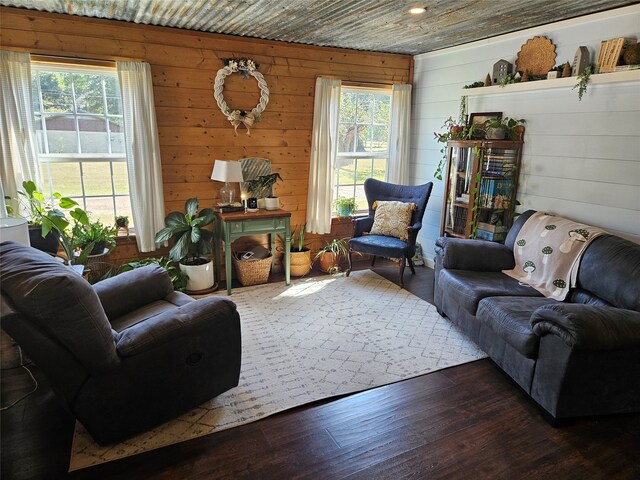 living room featuring wooden walls, dark hardwood / wood-style floors, and plenty of natural light