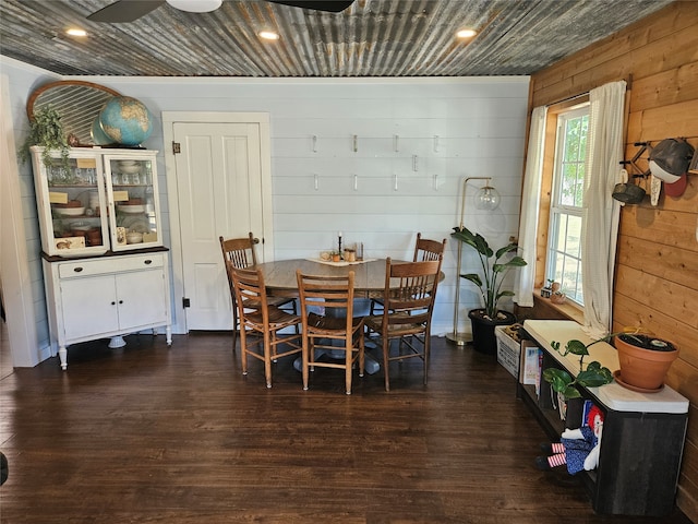 dining room featuring wooden walls, dark hardwood / wood-style flooring, and ceiling fan