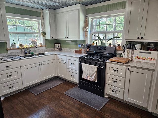 kitchen with white cabinets, sink, dark wood-type flooring, and black gas range