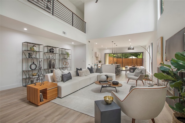 living room with a high ceiling and light wood-type flooring