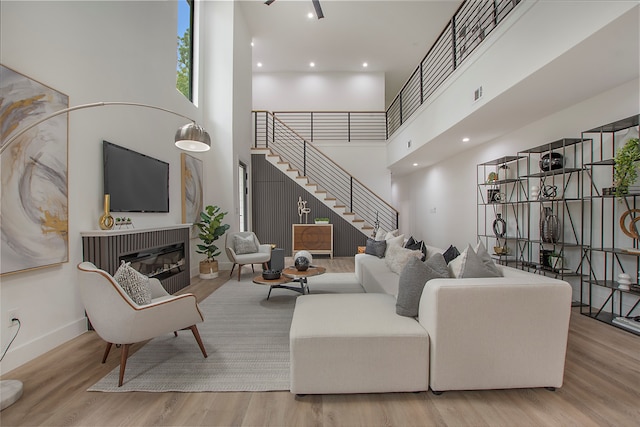 living room with a high ceiling and light hardwood / wood-style floors