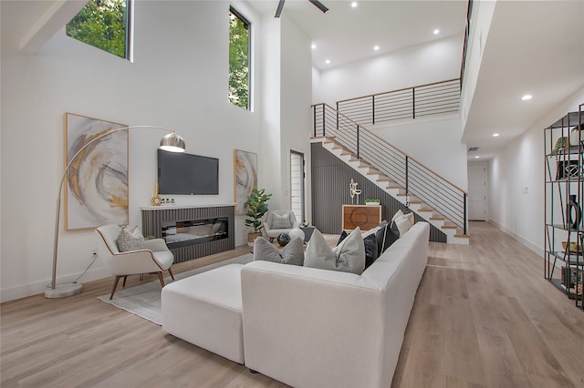 living room with a high ceiling and light wood-type flooring