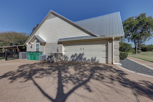 view of side of home featuring central AC and a garage