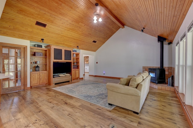 living room featuring wooden ceiling, lofted ceiling with beams, light hardwood / wood-style flooring, and a wood stove