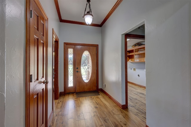 foyer entrance with ornamental molding and light hardwood / wood-style floors