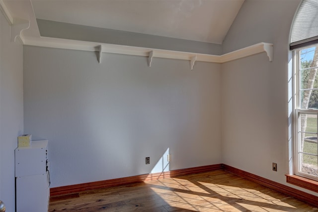 empty room with light wood-type flooring and lofted ceiling