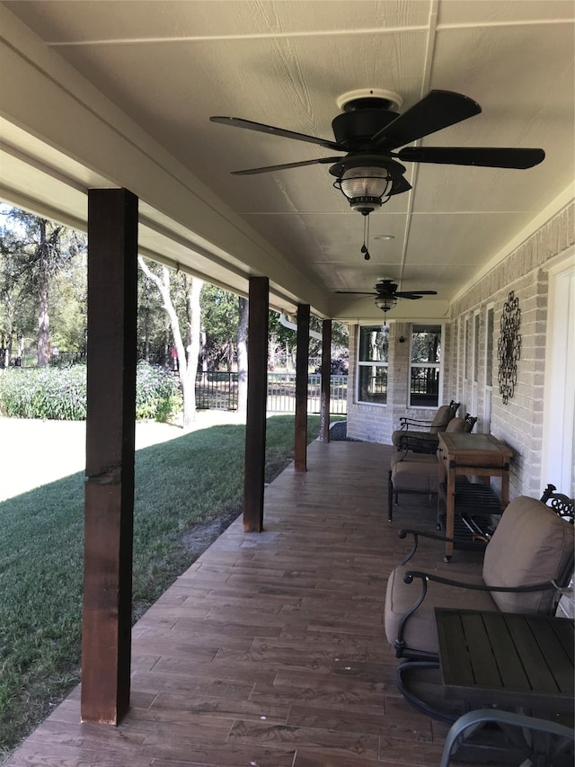 wooden terrace with ceiling fan and a yard