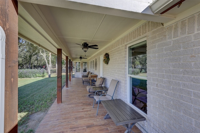 wooden deck with a lawn, ceiling fan, and covered porch