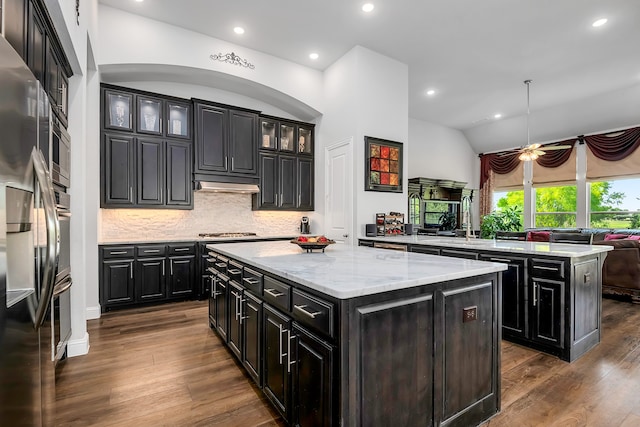 kitchen featuring sink, decorative light fixtures, appliances with stainless steel finishes, kitchen peninsula, and a kitchen island