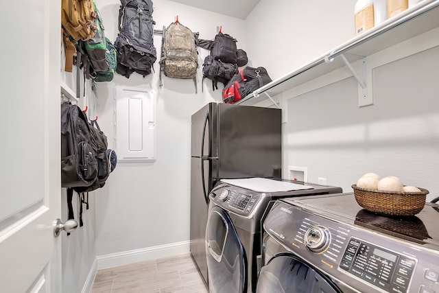 clothes washing area with washing machine and clothes dryer and electric panel