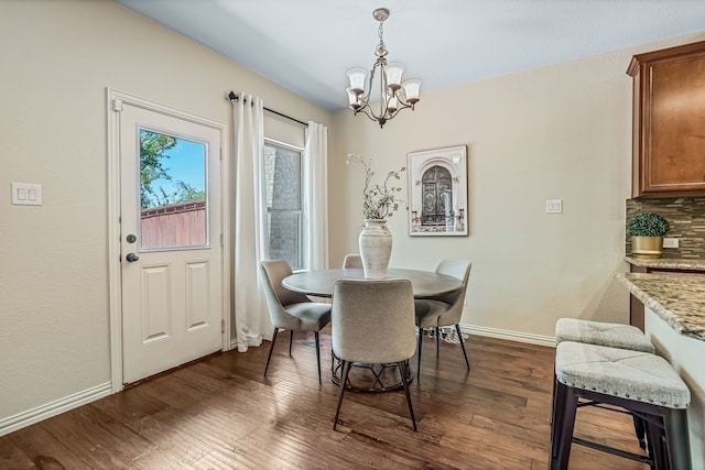 dining space featuring an inviting chandelier and dark hardwood / wood-style flooring