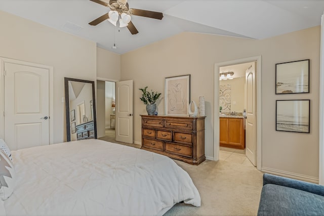 carpeted bedroom with ceiling fan, ensuite bathroom, and vaulted ceiling