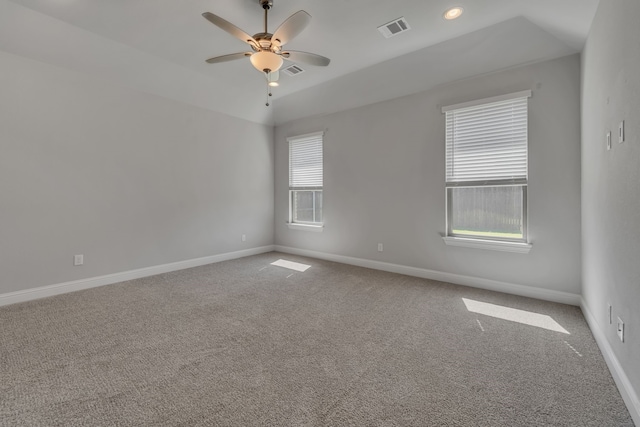 carpeted empty room with lofted ceiling, ceiling fan, and a healthy amount of sunlight