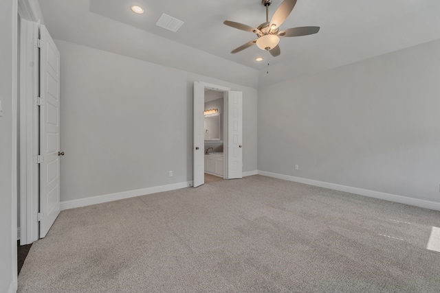 unfurnished bedroom with ceiling fan, ensuite bathroom, and light carpet