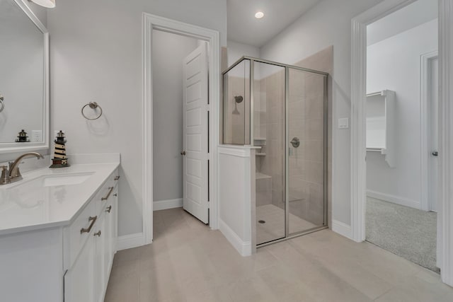 bathroom featuring vanity, a shower with shower door, and tile patterned flooring