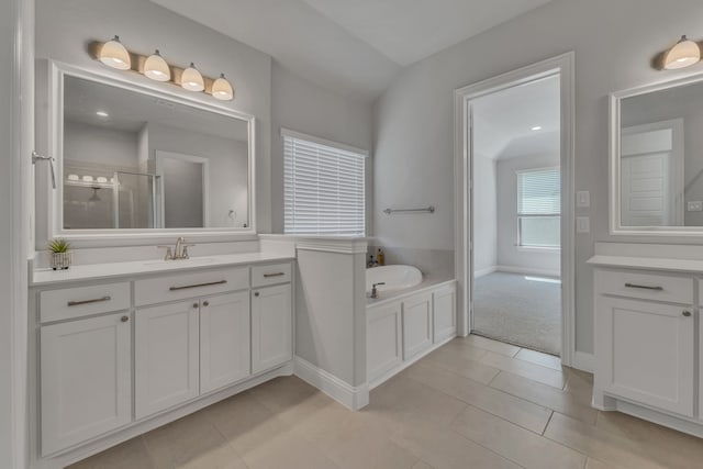 bathroom with vanity, vaulted ceiling, separate shower and tub, and tile patterned flooring