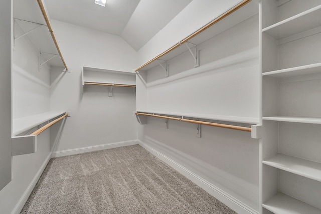 spacious closet featuring light colored carpet and vaulted ceiling