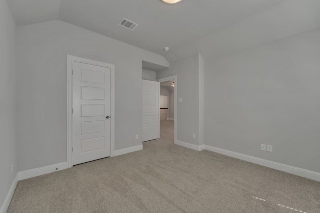 unfurnished bedroom with lofted ceiling and light carpet