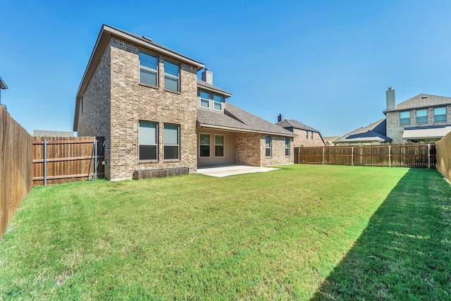 rear view of house with a yard and a patio