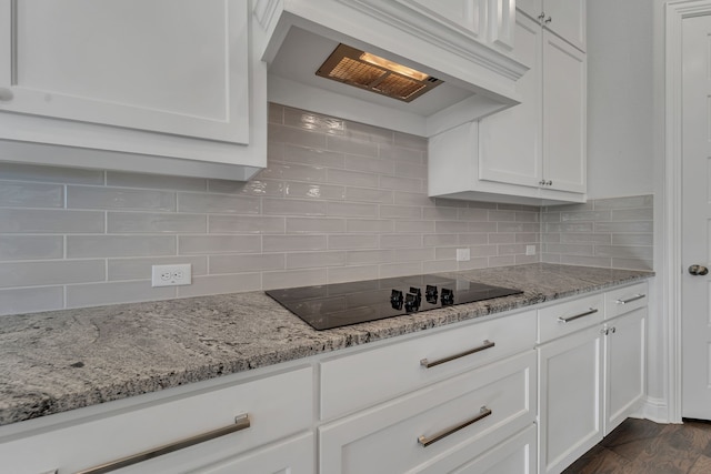 kitchen with dark wood-type flooring, decorative backsplash, white cabinets, and extractor fan