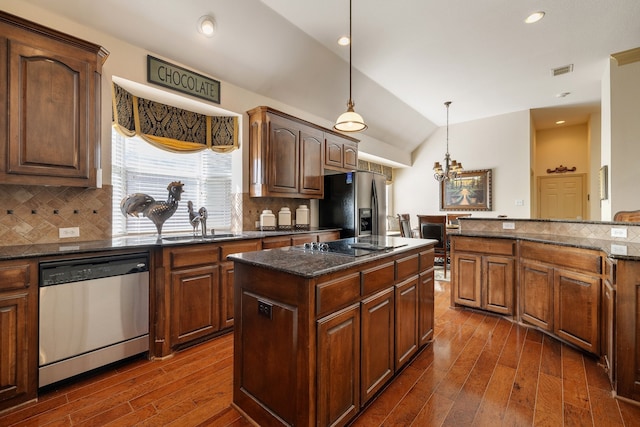 kitchen with tasteful backsplash, a kitchen island, stainless steel appliances, vaulted ceiling, and dark wood-type flooring