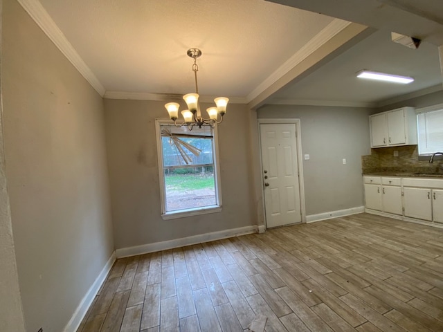 kitchen featuring light wood-type flooring, decorative light fixtures, an inviting chandelier, and white cabinetry