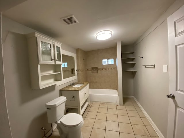 full bathroom featuring tile patterned flooring, vanity, toilet, and tiled shower / bath combo