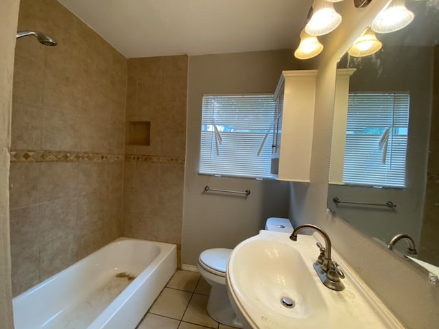 full bathroom with tiled shower / bath combo, toilet, a healthy amount of sunlight, and sink